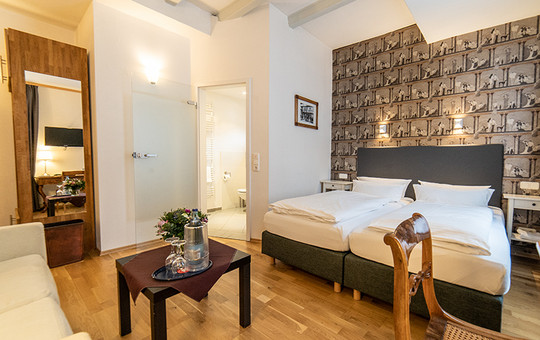 Doppelbett mit einem Sofa und Beistelltisch in einem der Hotelzimmer in Goslar.