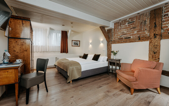 Rustikales Zimmer mit Ziegelwand, Holzdecke und edler Einrichtung.
