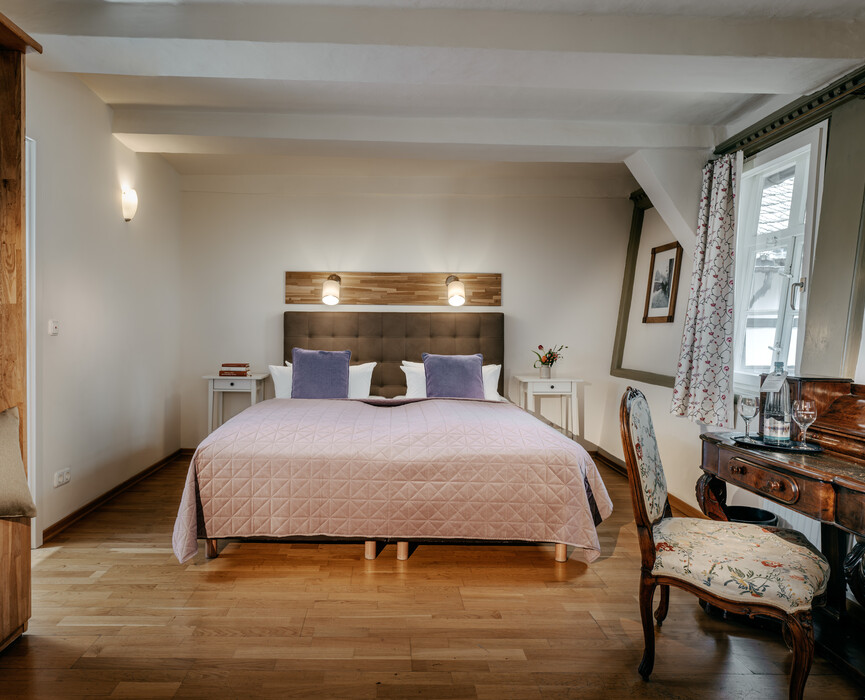 Ruhiges Doppelzimmer mit stilvoller Einrichtung und warmer Farbgebung.