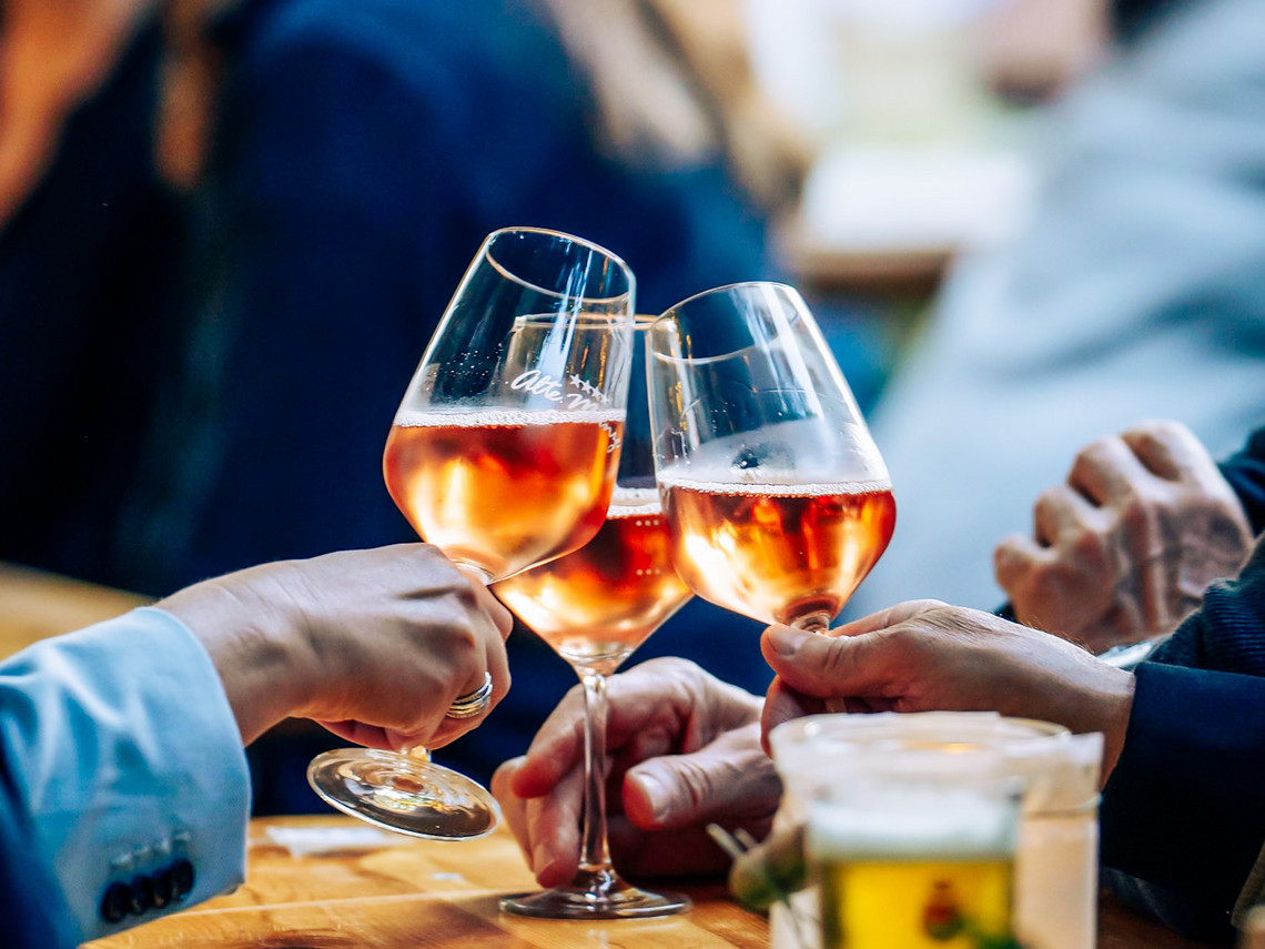 Gäste stoßen beim Goslarer Weinfest mit Weingläsern an