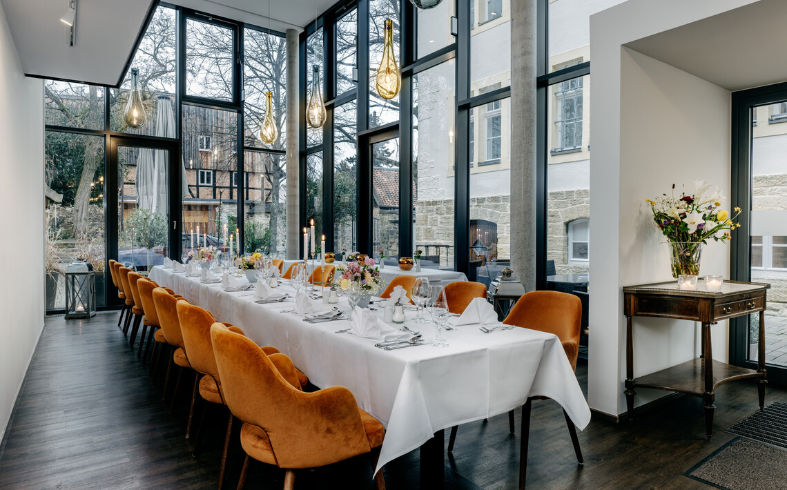Festlich gedeckter Wintergarten mit großzügigen Fensterfronten im Romantik Hotel Alte Münze.